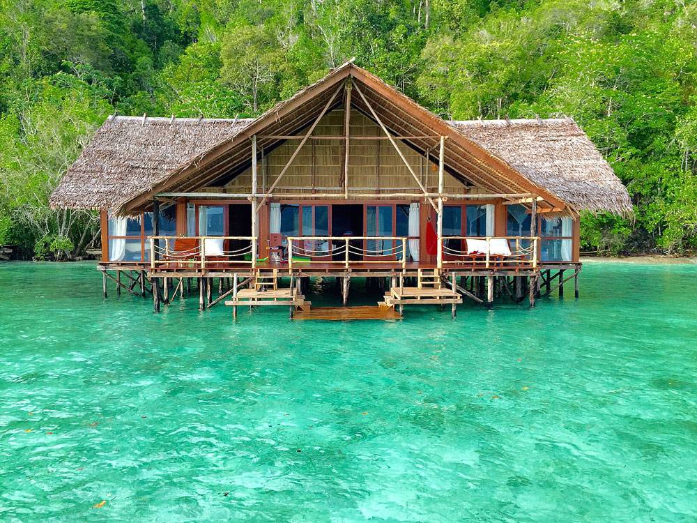 Tauchreise Indonesien | Papua Explorers Dive Resort | Stelzenbungalows in Raja Ampat in türkisblauem Wasser