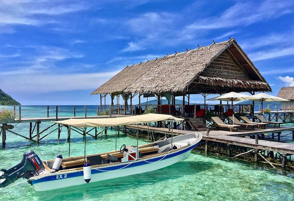 Tauchreise Indonesien | Papua Explorers Dive Resort | Stelzenbungalows in Raja Ampat mit Beiboot